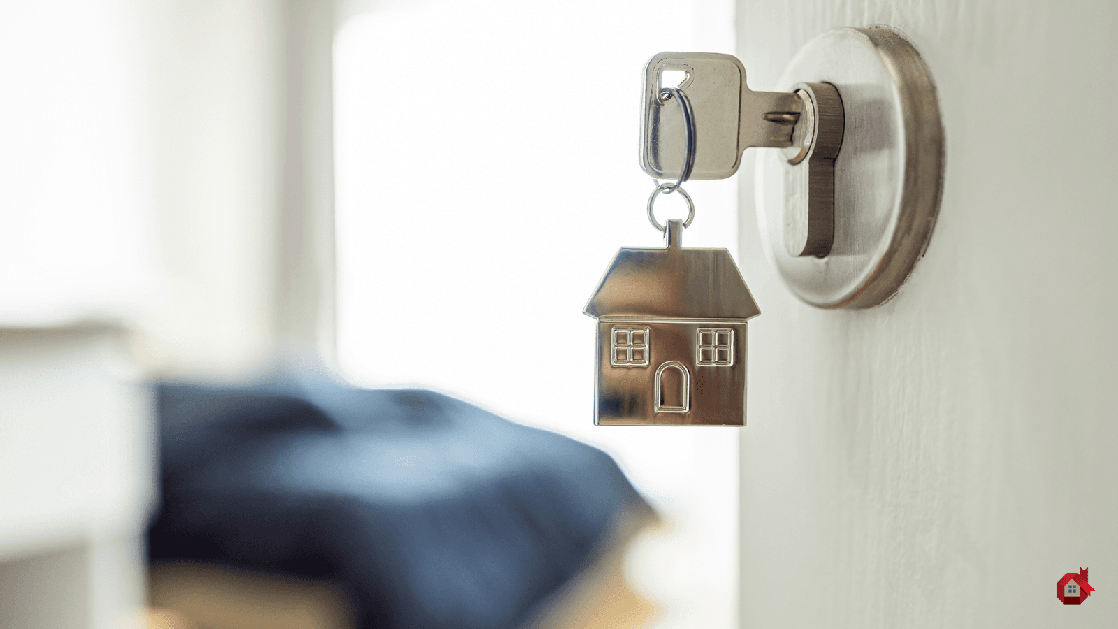 Des clés dans une porte avec une maison.