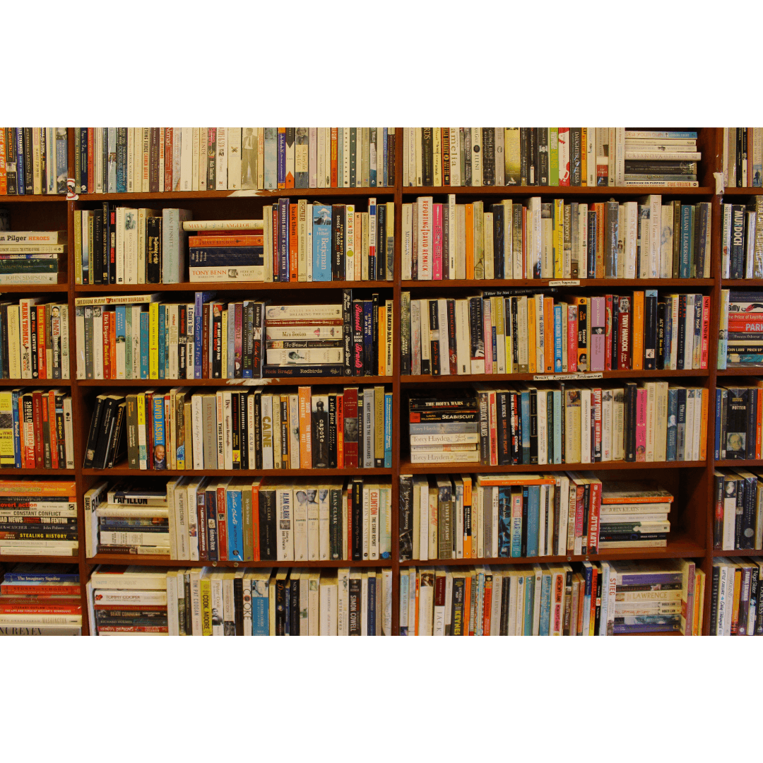 Bibliothèque en bois remplie de livres variés, représentant la culture littéraire et l’organisation parfaite d’un amour pour la lecture.