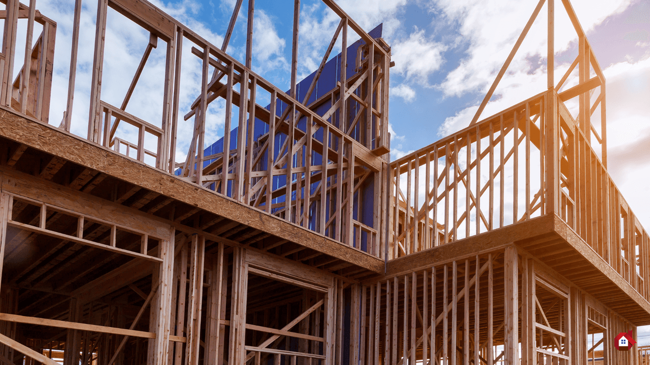 Structure à ossature de bois en cours de construction pour une maison à plusieurs étages sous un ciel bleu nuageux