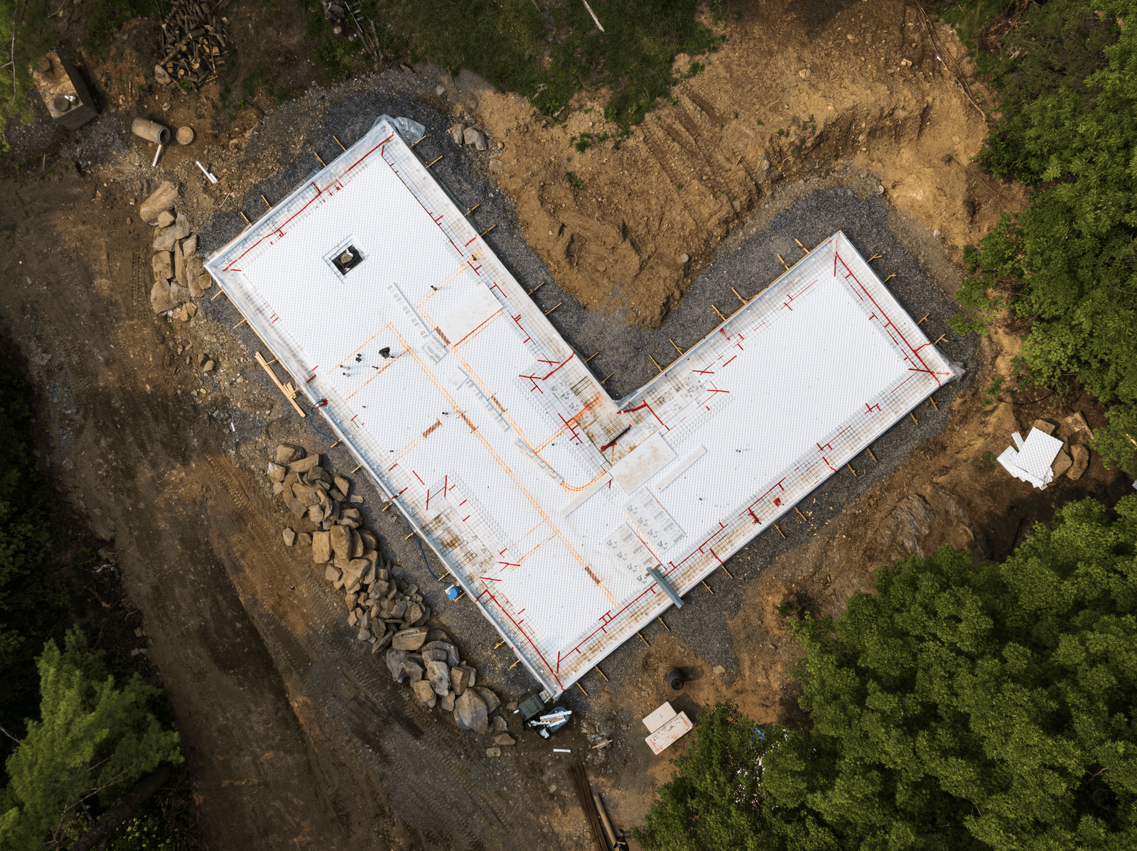 Vue aérienne d’un chantier avec dalle isolante en polystyrène et tuyaux de chauffage radiant en cours d'installation