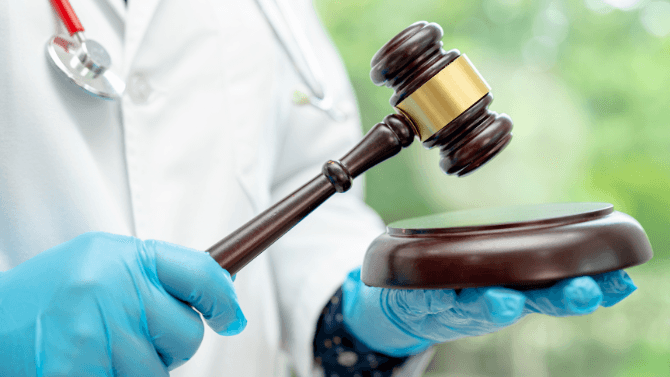 medecin tenant un marteau de juge 