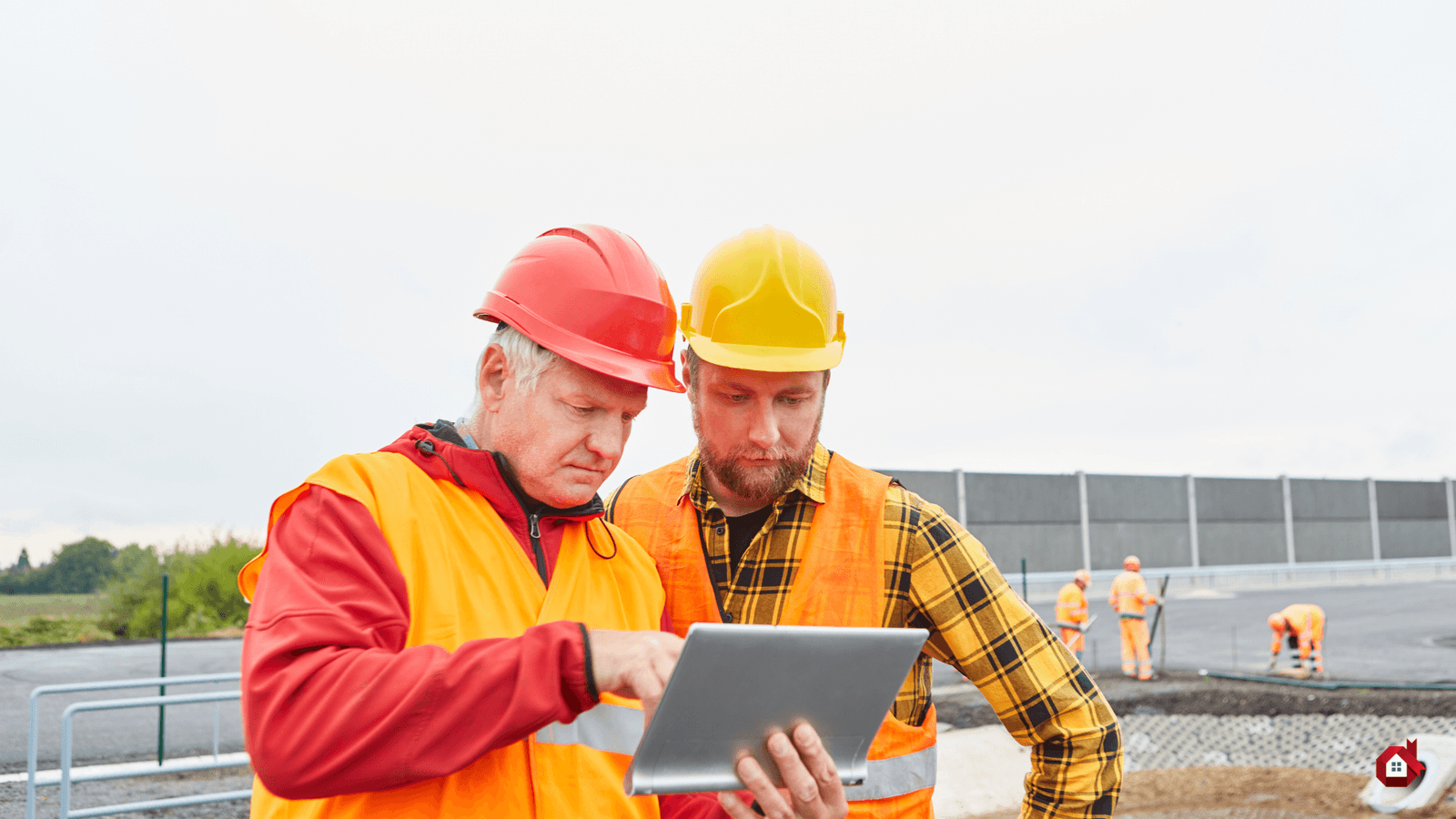 deux hommes devant un ordinateur sur un chantier de construction 