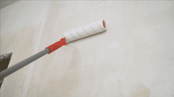 Application d'un primer avant peinture à la chaux sur mur 