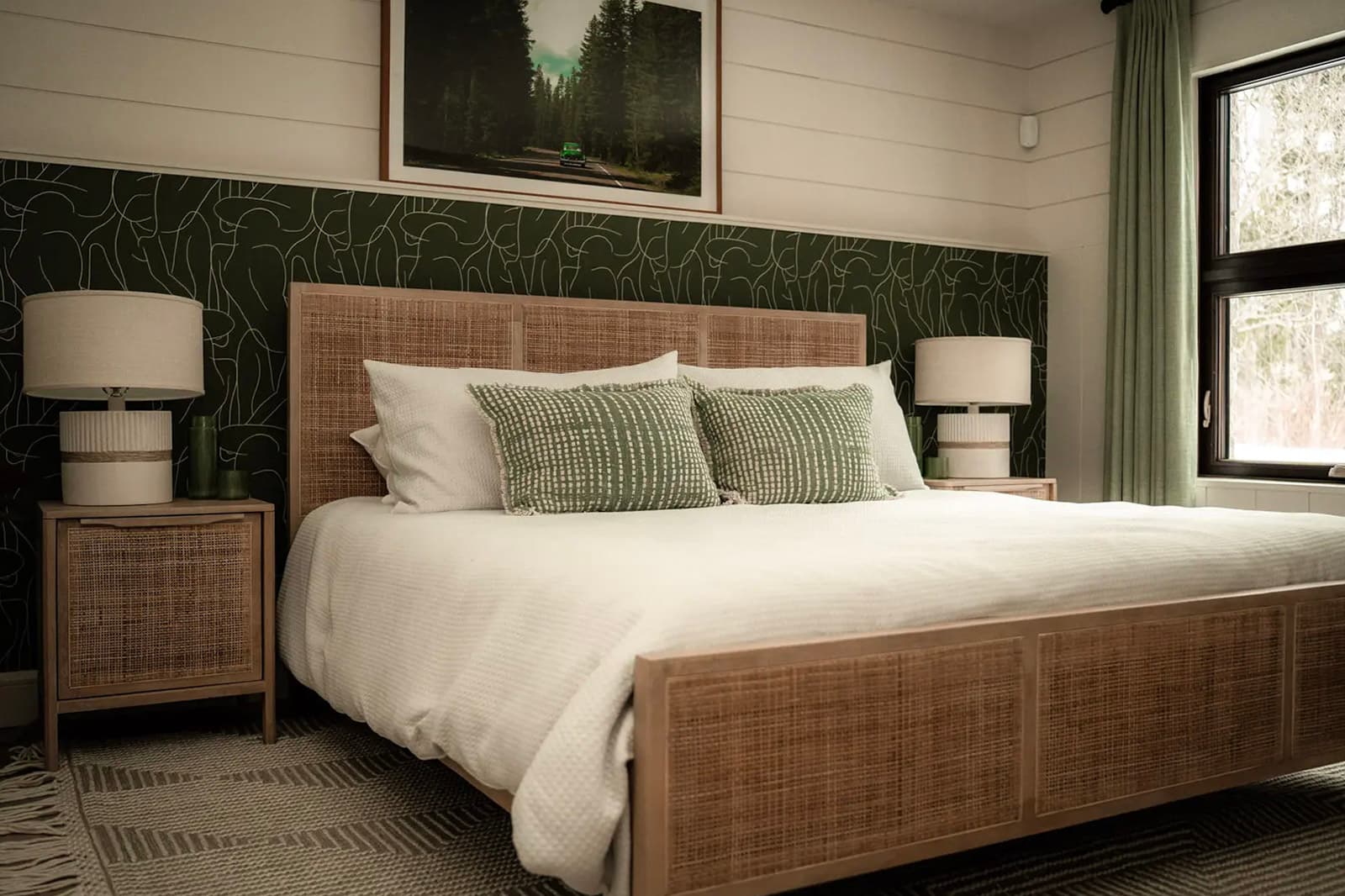 Chambre à coucher chaleureuse avec lit en bois tressé, mur accent vert et décoration naturelle.