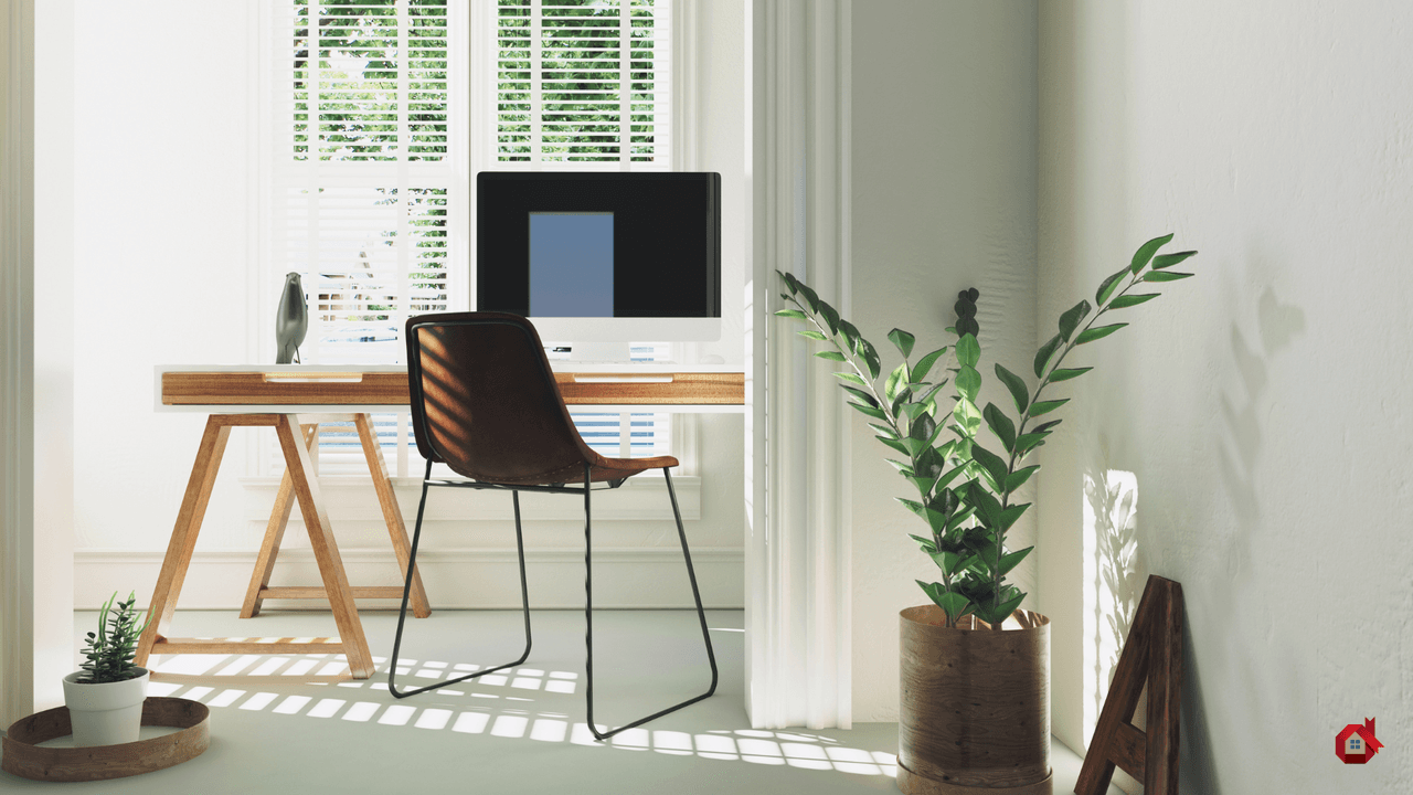 Bureau de télétravail lumineux et minimaliste en bois blanc placé devant une fenêtre à persiennes, équipé d'un ordinateur et d'une chaise en cuir marron