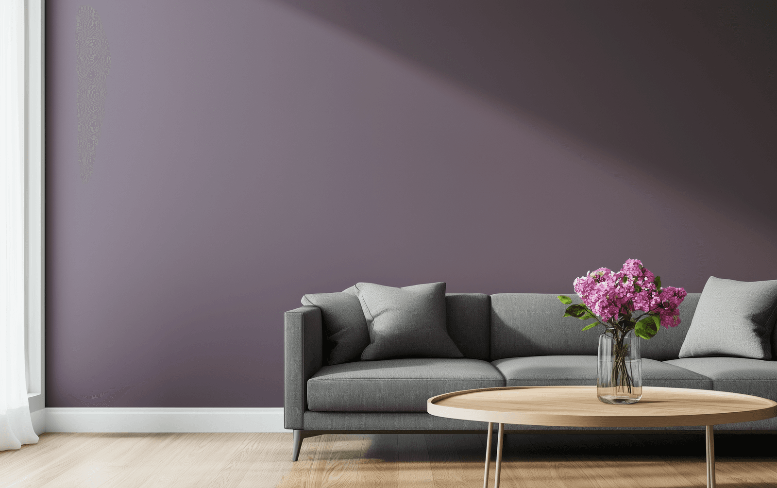 Salon moderne avec mur violet foncé, canapé gris minimaliste, table basse en bois clair et vase de fleurs roses.