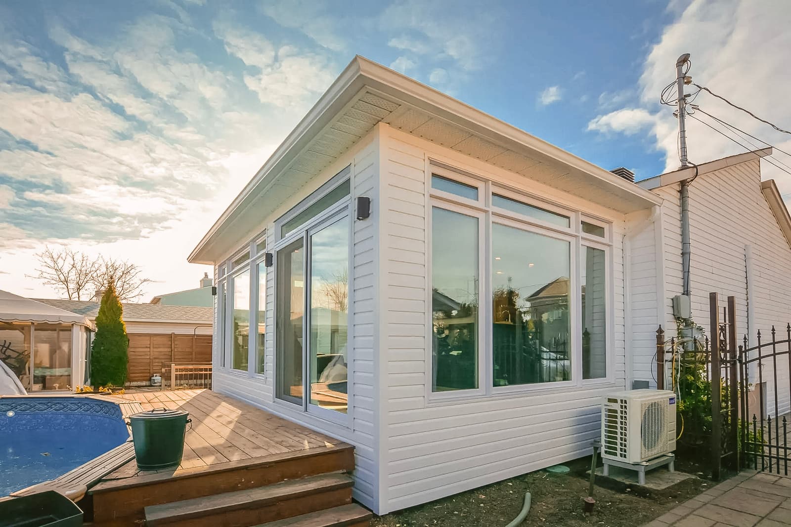 Agrandissement lumineux avec fenêtres panoramiques, terrasse en bois et isolation écoénergétique.