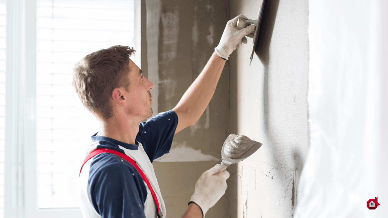 entrepreneur mettant de l'enduit au mur