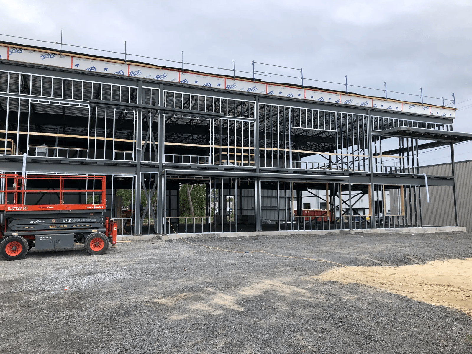 Construction d’un bâtiment commercial à ossature d’acier avec échafaudages et nacelle élévatrice sur chantier