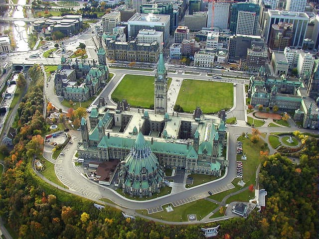 Vue aérienne panoramique des édifices du Parlement du Canada à Ottawa avec leurs toits verts caractéristiques et la tour de la Paix