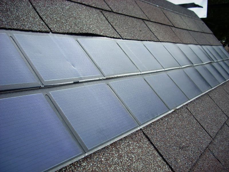 Rangée de bardeaux solaires photovoltaïques intégrée directement sur une toiture résidentielle en bardeaux d'asphalte.